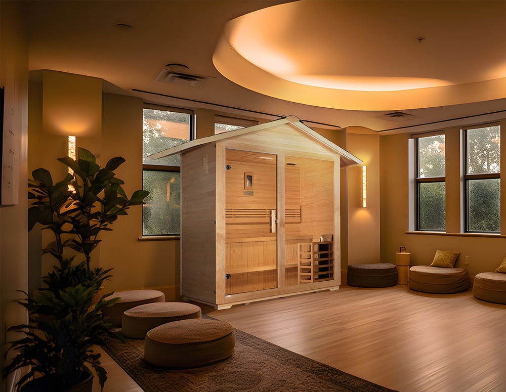 Golden Designs "Arlberg" 3 Person Traditional Outdoor Sauna in Canadian hemlock placed in a warmly lit spa lounge from Wish Rock Relaxation